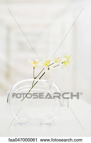 Stock Image - Piggy bank used as flower vase. Fotosearch