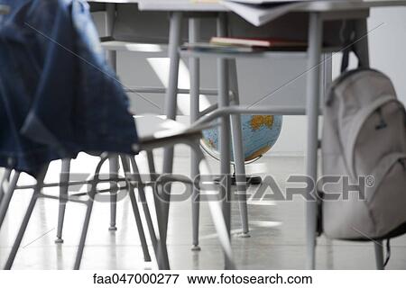 Stock Photo - School desk and chair, globe sitting on floor in background. Fotosearch