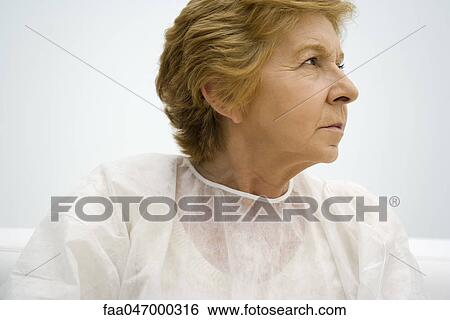 Senior woman wearing examination gown, looking away, portrait View Large Photo Image Stock Photograph - Senior woman wearing examination gown, looking away, portrait. Fotosearch