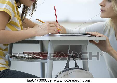 Teacher assisting student, cropped View Large Photo Image Stock Photo - Teacher assisting student, cropped. Fotosearch