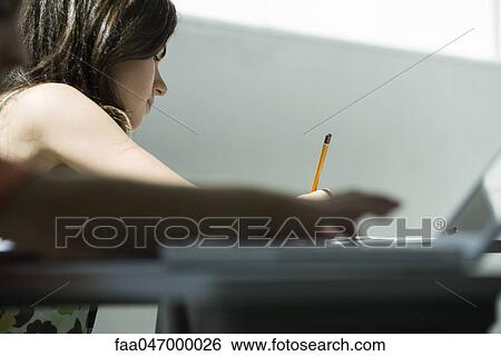 Stock Photograph - Teenage girl writing at desk. Fotosearch