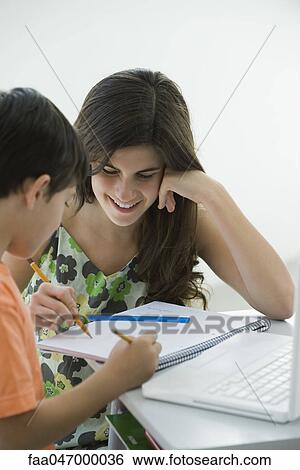 Stock Photograph - Tutor helping elementary school student. Fotosearch
