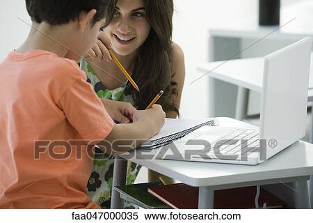 Tutor helping elementary school student View Large Photo Image Stock Photography - Tutor helping elementary school student. Fotosearch
