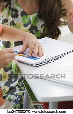Stock Image - Tutor working with elementary school student. Fotosearch