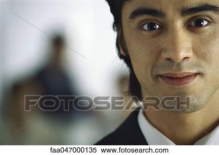 Stock Photography - Young businessman smiling at camera, portrait. Fotosearch