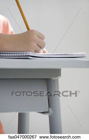Stock Photo - Young student writing in notebook, cropped. Fotosearch
