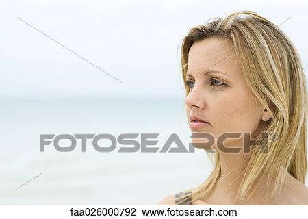 Blonde woman looking into distance, sea in background, head and shoulders View Large Photo Image Stock Image - Blonde woman looking into distance, sea in background, head and shoulders. Fotosearch