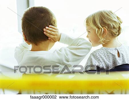 Boy and girl, boy covering ears, girl looking at boy, rear view View Large Photo Image Stock Image - Boy and girl, boy covering ears, girl looking at boy, rear view. Fotosearch