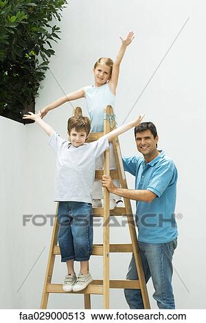 Boy and girl standing on ladder with arms in the air, father holding ladder, all smiling at camera View Large Photo Image Stock Image - Boy and girl standing on ladder with arms in the air, father holding ladder, all smiling at camera. Fotosearch