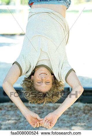 Boy hanging upside down View Large Photo Image Picture - Boy hanging upside down. Fotosearch