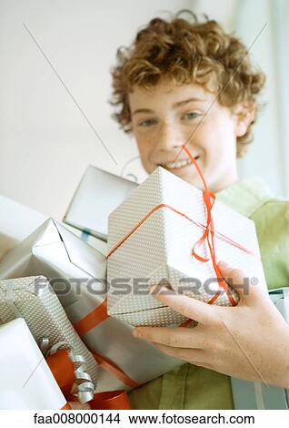 Picture - Boy holding armful of presents. Fotosearch