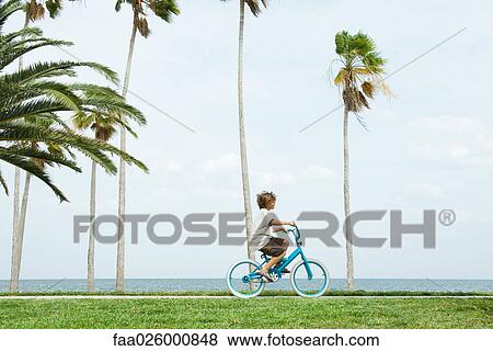 Boy riding bicycle at the beach, side view View Large Photo Image Stock Photo - Boy riding bicycle at the beach, side view. Fotosearch