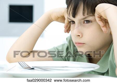 Boy sulking at dinner table, close-up View Large Photo Image Stock Image - Boy sulking at dinner table, close-up. Fotosearch