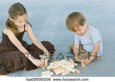 Brother and sister sitting on the ground, playing with building blocks together View Large Photo Image Stock Photograph - Brother and sister sitting on the ground, playing with building blocks together. Fotosearch