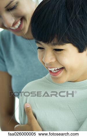 Brother and sister smiling together, both looking down View Large Photo Image Stock Photography - Brother and sister smiling together, both looking down. Fotosearch