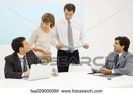 Stock Photo - Business executives working together in office. Fotosearch