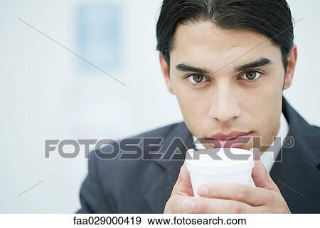 Businessman holding disposable cup, close-up, portrait View Large Photo Image Stock Photo - Businessman holding disposable cup, close-up, portrait. Fotosearch