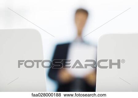 Businessman holding document, defocused View Large Photo Image Stock Photo - Businessman holding document, defocused. Fotosearch