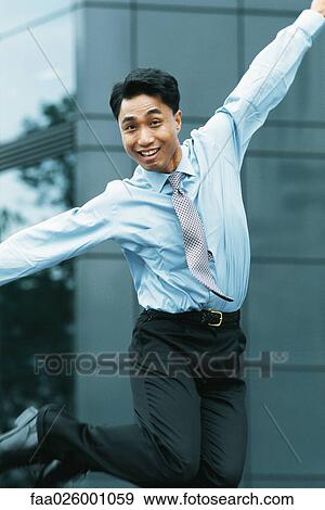 Businessman jumping in the air, arms out, smiling at camera View Large Photo Image Stock Photo - Businessman jumping in the air, arms out, smiling at camera. Fotosearch
