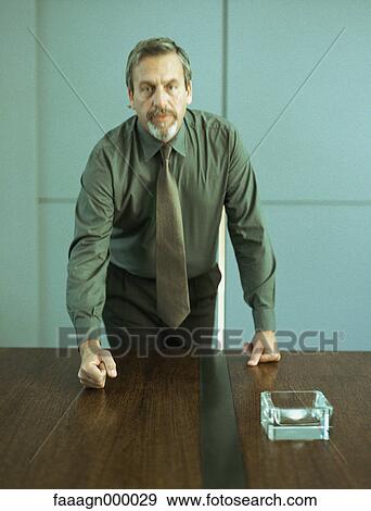 Businessman pounding fist on table, portrait View Large Photo Image Stock Photo - Businessman pounding fist on table, portrait. Fotosearch
