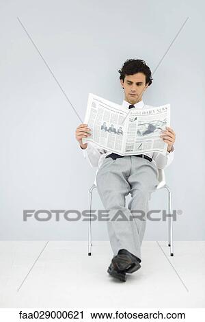 Businessman slouching in chair, reading newspaper View Large Photo Image Stock Image - Businessman slouching in chair, reading newspaper. Fotosearch