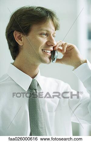 Businessman using cell phone, smiling, looking away View Large Photo Image Stock Photograph - Businessman using cell phone, smiling, looking away. Fotosearch