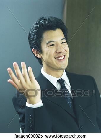 Stock Photography - Businessman with hand up, smiling, portrait. Fotosearch