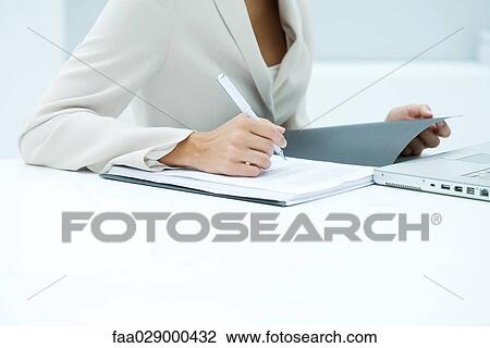 Businesswoman reading over file, cropped View Large Photo Image Stock Image - Businesswoman reading over file, cropped. Fotosearch