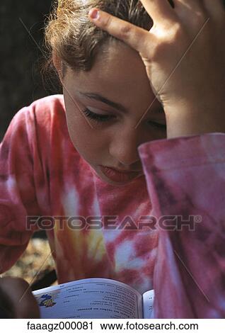 Stock Image - Child doing homework, holding head. Fotosearch