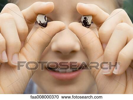 Child holding up seeds in front of eyes View Large Photo Image Stock Image - Child holding up seeds in front of eyes. Fotosearch