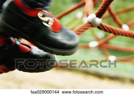 Picture - Child on playground, close-up of shoes, cropped. Fotosearch