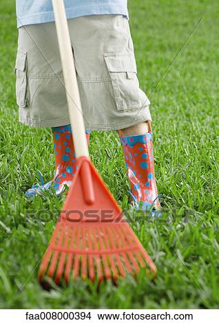 Child standing with rake, waist down View Large Photo Image Picture - Child standing with rake, waist down. Fotosearch