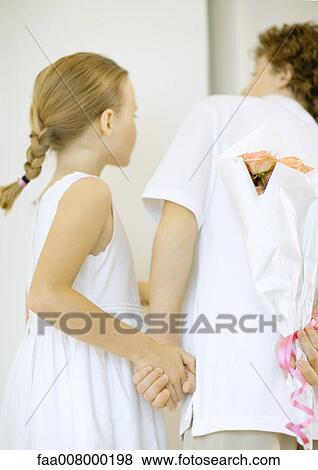 Children holding bouquet of roses behind back, looking around corner View Large Photo Image Stock Photo - Children holding bouquet of roses behind back, looking around corner. Fotosearch