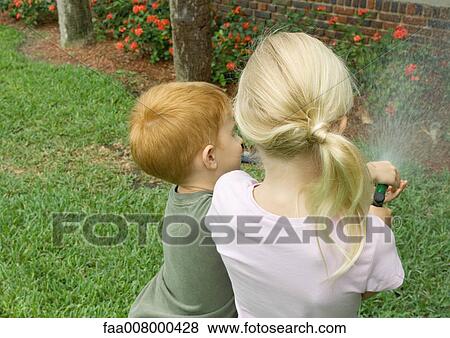 Children spraying plants together View Large Photo Image Stock Photo - Children spraying plants together. Fotosearch