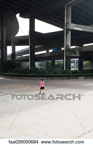 China, Guangzhou, female pedestrian walking under bridge, rear view View Large Photo Image Picture - China, Guangzhou, female pedestrian walking under bridge, rear view. Fotosearch