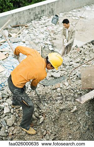 Construction worker digging at construction site, high angle view View Large Photo Image Stock Photography - Construction worker digging at construction site, high angle view. Fotosearch