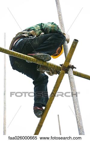 Construction worker on scaffolding, low angle view View Large Photo Image Stock Photography - Construction worker on scaffolding, low angle view. Fotosearch