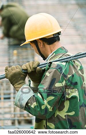 Construction worker wearing camouflage and hard hat carrying metal rod on shoulder, side view View Large Photo Image Stock Image - Construction worker wearing camouflage and hard hat carrying metal rod on shoulder, side view. Fotosearch