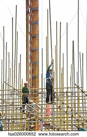 Construction workers on standing on scaffolding, low angle view View Large Photo Image Stock Image - Construction workers on standing on scaffolding, low angle view. Fotosearch