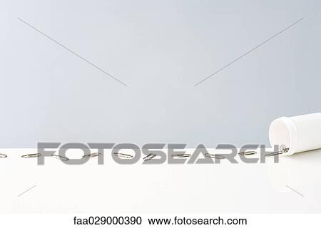 Stock Image - Container spilling paper clips. Fotosearch