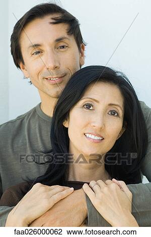 Couple embracing, both smiling at camera, portrait View Large Photo Image Stock Image - Couple embracing, both smiling at camera, portrait. Fotosearch