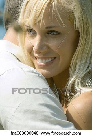 Couple embracing, close-up of woman smiling View Large Photo Image Stock Photo - Couple embracing, close-up of woman smiling. Fotosearch