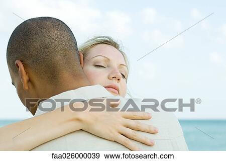 Couple embracing, woman's eyes closed, rear view View Large Photo Image Stock Photo - Couple embracing, woman's eyes closed, rear view. Fotosearch