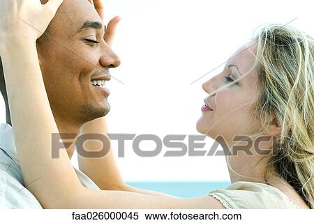 Couple face to face with eyes closed, woman touching man's head View Large Photo Image Stock Photography - Couple face to face with eyes closed, woman touching man's head. Fotosearch