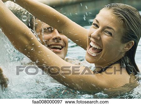 Couple laughing in swimming pool View Large Photo Image Stock Photo - Couple laughing in swimming pool. Fotosearch