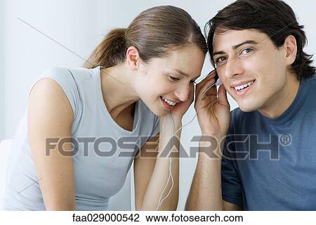 Couple listening to earphones together, smiling View Large Photo Image Stock Image - Couple listening to earphones together, smiling. Fotosearch