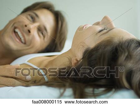 Couple lying in bed together, laughing View Large Photo Image Stock Photography - Couple lying in bed together, laughing. Fotosearch