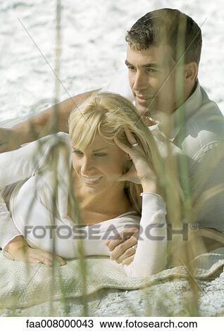 Couple lying on beach View Large Photo Image Stock Image - Couple lying on beach. Fotosearch