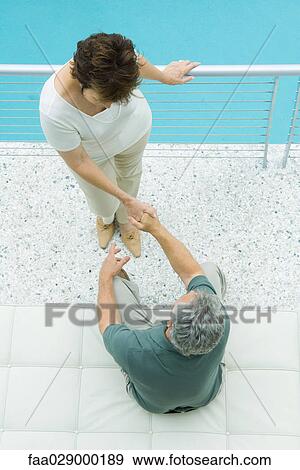 Couple on balcony, holding hands, high angle view View Large Photo Image Stock Photo - Couple on balcony, holding hands, high angle view. Fotosearch