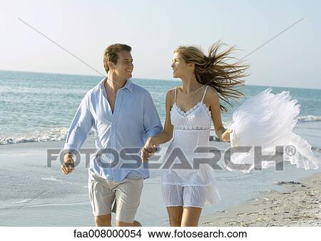 Couple running on beach View Large Photo Image Picture - Couple running on beach. Fotosearch